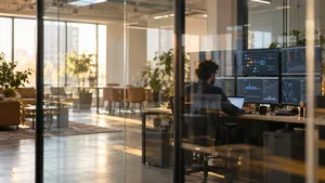 Data engineer at a wall of pipeline dashboards seen through a glass partition